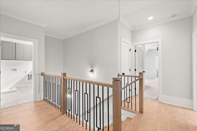 hallway with crown molding and light wood-type flooring