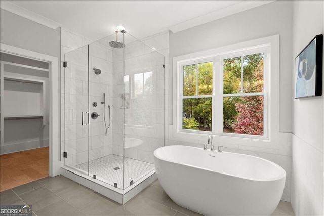 bathroom featuring independent shower and bath, crown molding, tile walls, and tile patterned floors