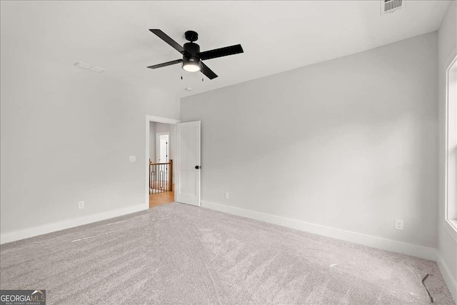 empty room with ceiling fan and light carpet