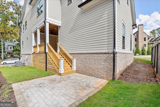 view of side of home with a yard and a patio area