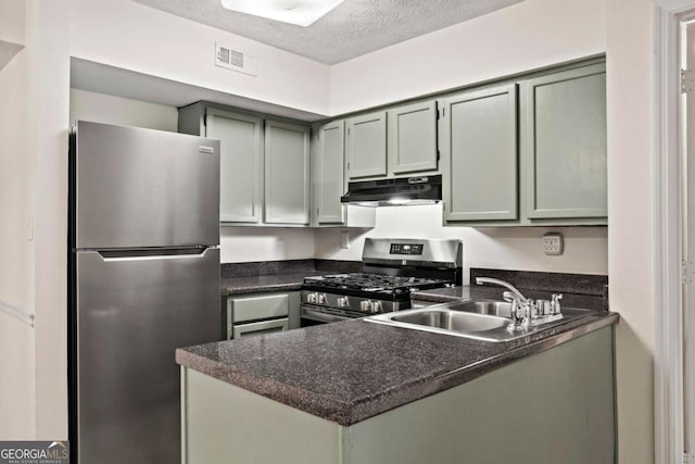 kitchen with sink, green cabinetry, a textured ceiling, and appliances with stainless steel finishes