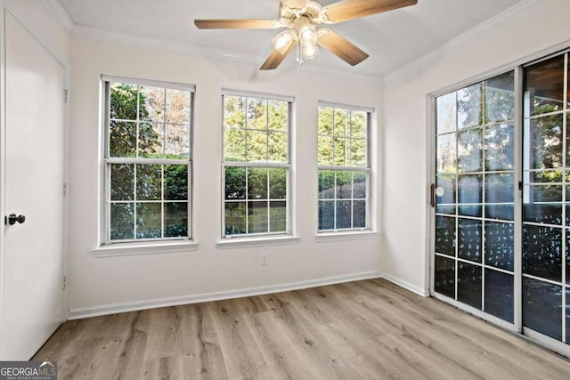 unfurnished sunroom featuring ceiling fan and a healthy amount of sunlight