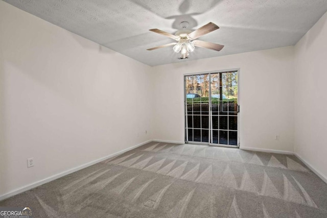 spare room featuring ceiling fan, light colored carpet, and a textured ceiling