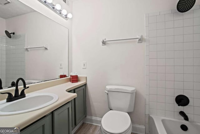 full bathroom featuring vanity, tiled shower / bath combo, toilet, and hardwood / wood-style flooring