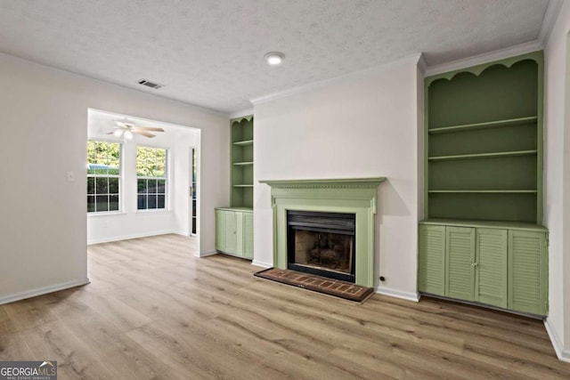 unfurnished living room featuring wood-type flooring, crown molding, a textured ceiling, and built in shelves