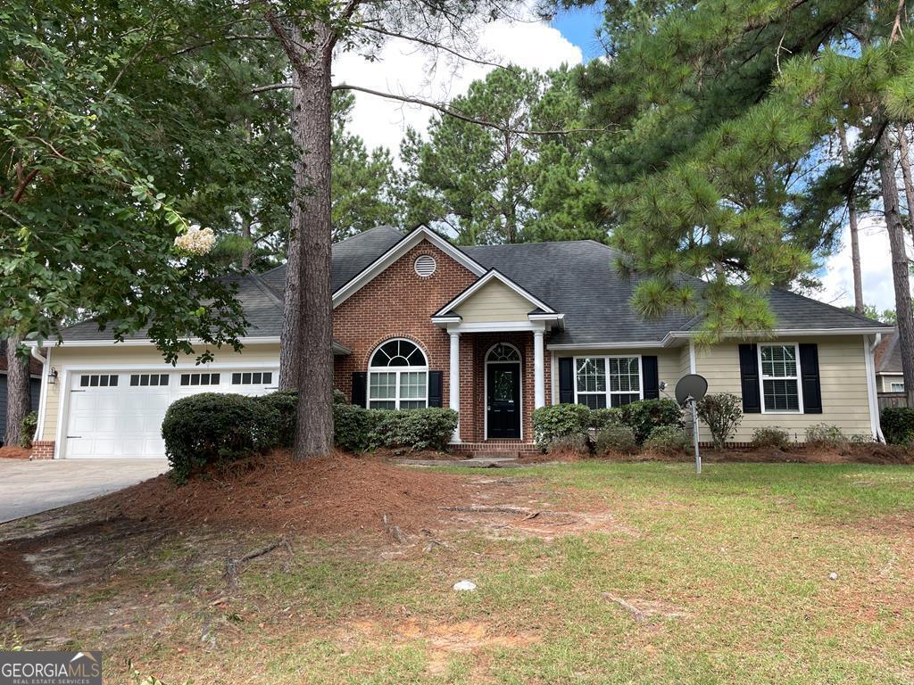 ranch-style house featuring a garage and a front yard