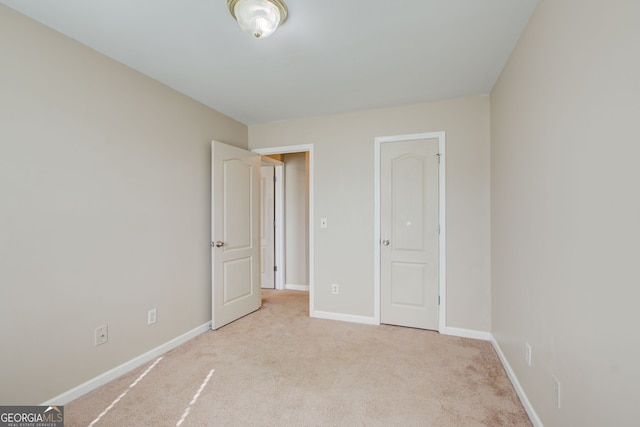 unfurnished bedroom featuring light carpet