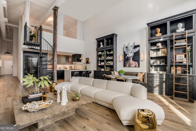 living room featuring a high ceiling and light wood-type flooring