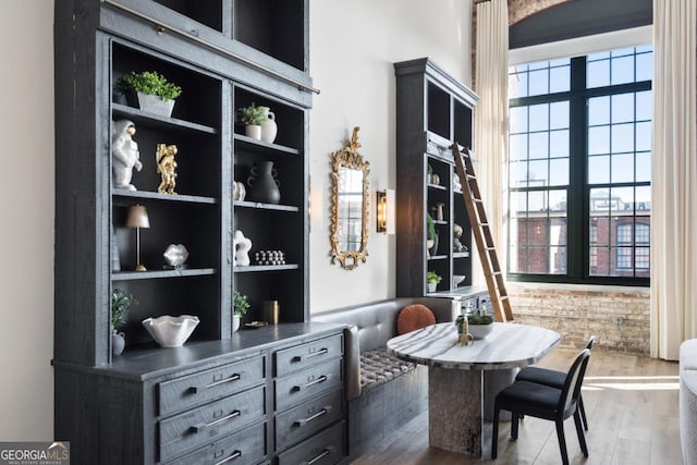 dining area with dark wood-type flooring, a wealth of natural light, and built in features