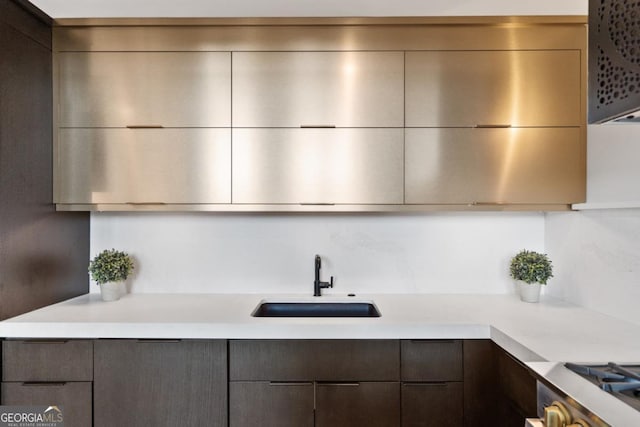 kitchen with dark brown cabinets, sink, and range