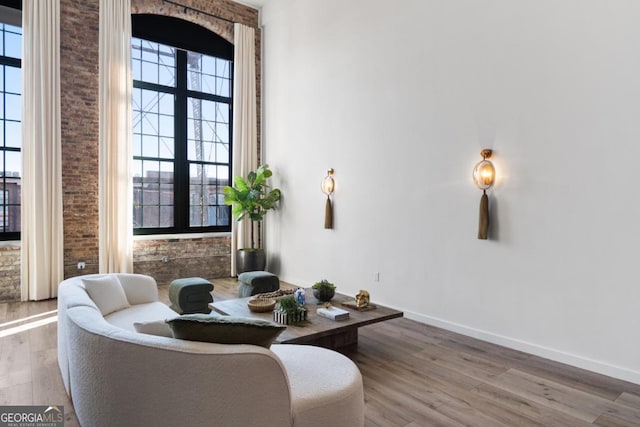 sitting room with hardwood / wood-style flooring and a high ceiling