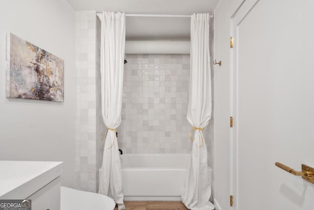 bathroom featuring hardwood / wood-style flooring, shower / tub combo with curtain, and vanity