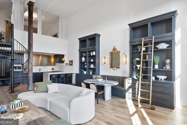 living room with a high ceiling and light hardwood / wood-style flooring