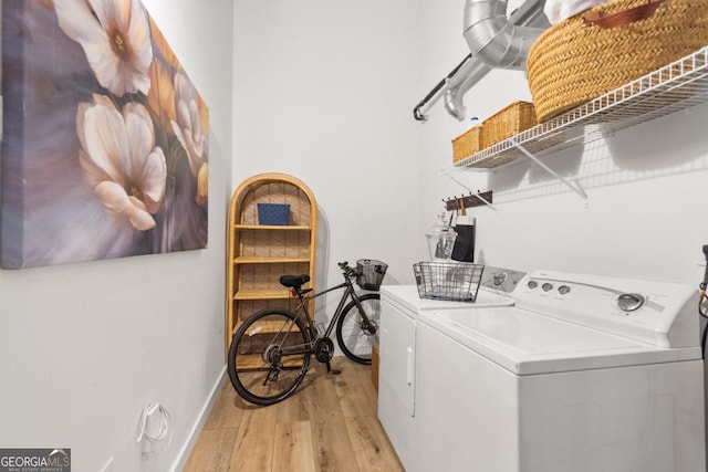 laundry room with washer and dryer and light wood-type flooring