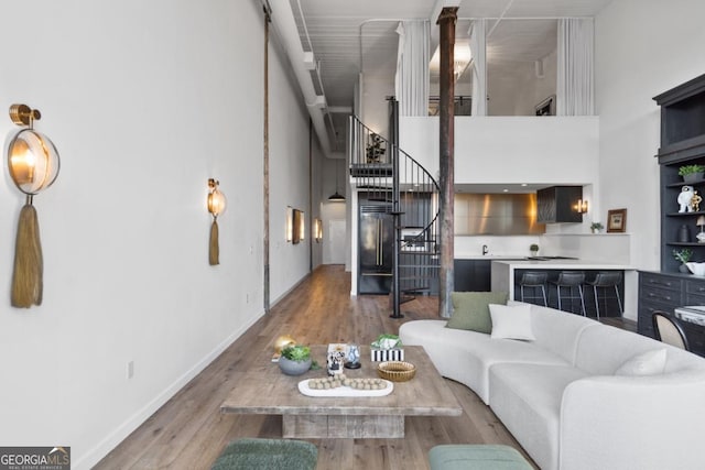 living room featuring a towering ceiling and wood-type flooring