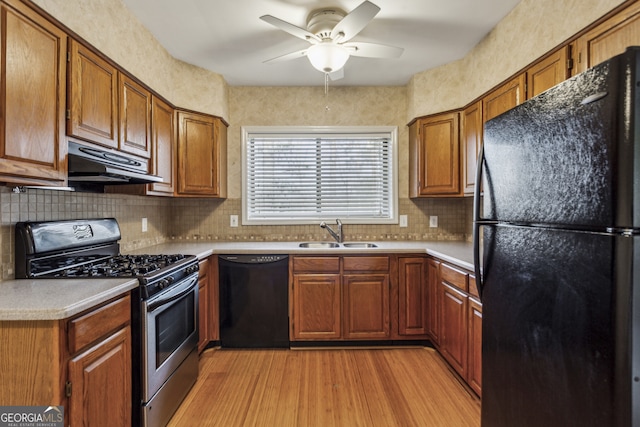 kitchen with tasteful backsplash, sink, ceiling fan, black appliances, and light hardwood / wood-style flooring