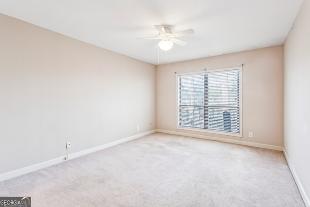 empty room featuring light colored carpet and ceiling fan