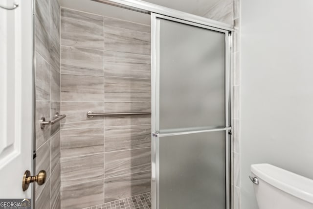 bathroom featuring an enclosed shower and toilet