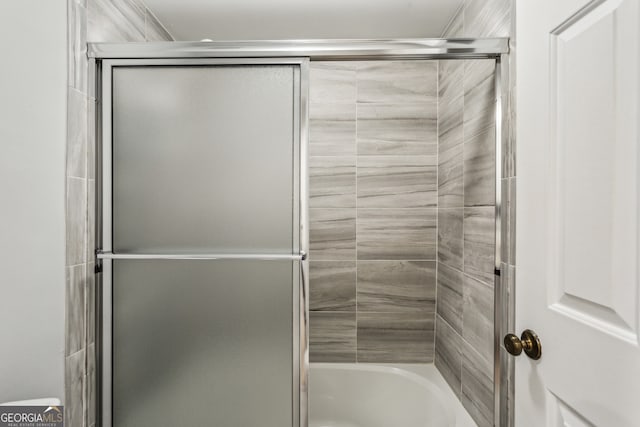 bathroom featuring shower / bath combination with glass door