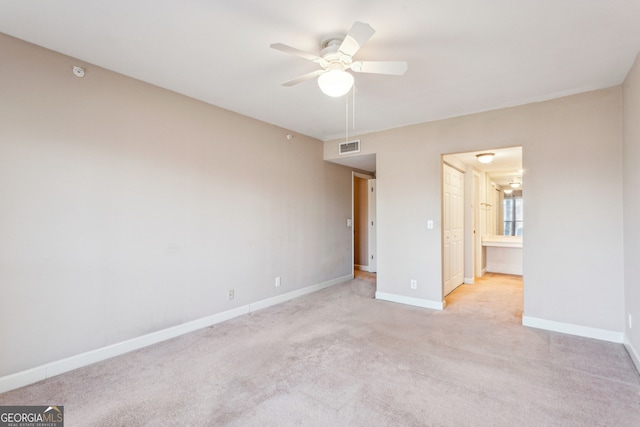 unfurnished bedroom with ceiling fan, light colored carpet, and connected bathroom