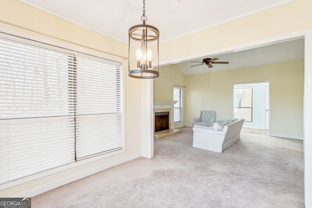 unfurnished living room with crown molding, vaulted ceiling, light carpet, and ceiling fan