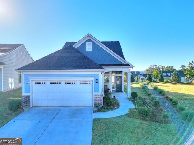 craftsman-style home featuring concrete driveway, roof with shingles, an attached garage, a front yard, and brick siding