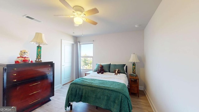 bedroom with light wood-type flooring, baseboards, visible vents, and ceiling fan