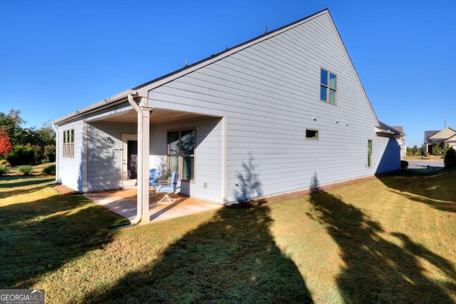 back of property featuring a patio and a yard