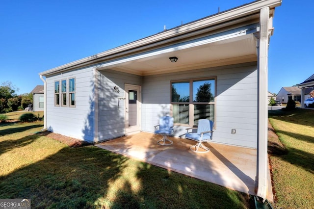 rear view of house featuring a yard and a patio