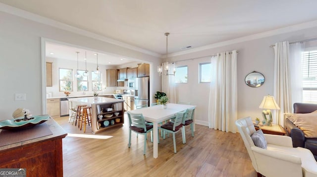 dining area featuring light wood-style floors, a healthy amount of sunlight, a notable chandelier, and visible vents