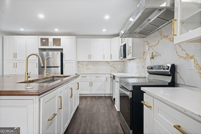 kitchen featuring dark wood-type flooring, white cabinetry, stainless steel appliances, tasteful backsplash, and ventilation hood