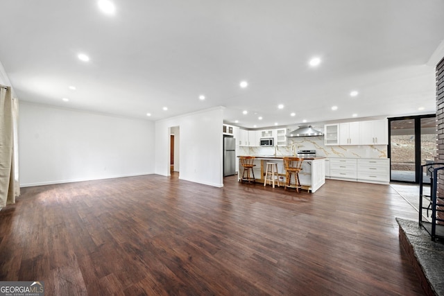 unfurnished living room with ornamental molding and dark hardwood / wood-style floors