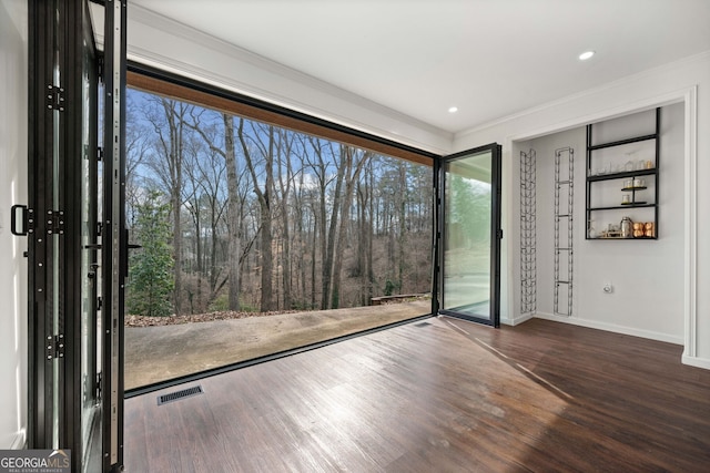 spare room featuring crown molding and wood-type flooring