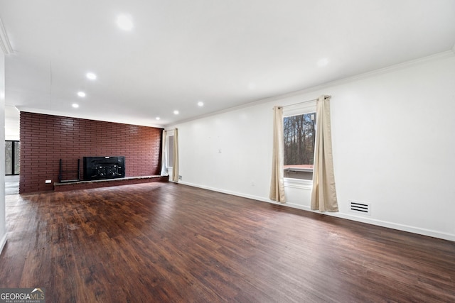 unfurnished living room with crown molding, dark hardwood / wood-style flooring, and a brick fireplace