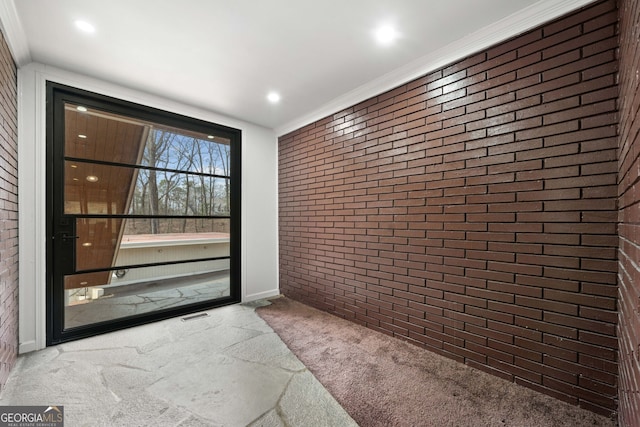 entryway featuring carpet and brick wall