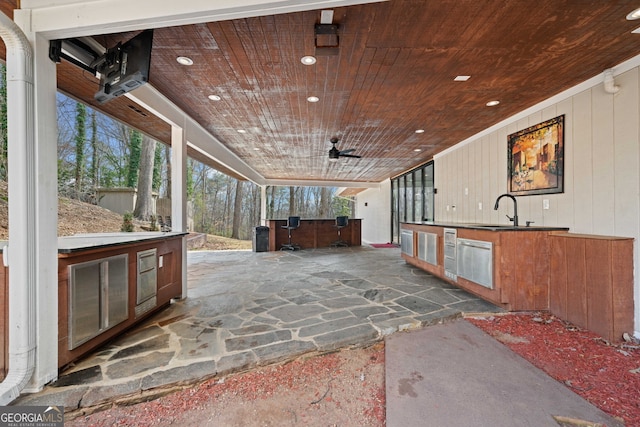 view of patio featuring sink, ceiling fan, and exterior kitchen