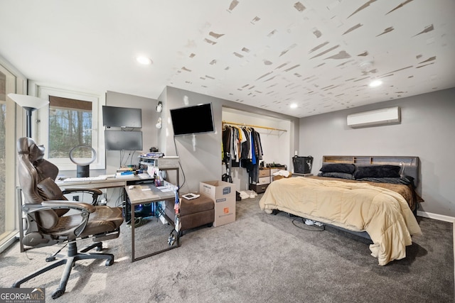 carpeted bedroom with a spacious closet, a wall mounted air conditioner, and a closet