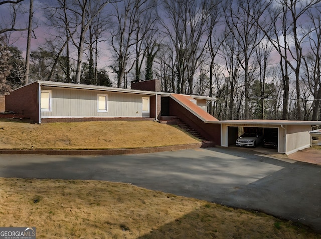 view of front of house with a carport and a yard