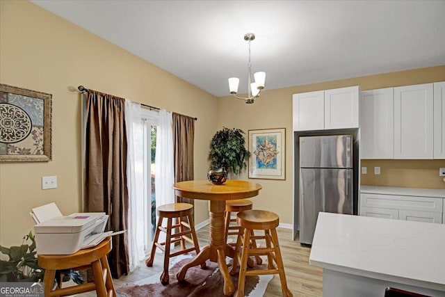 dining space featuring light hardwood / wood-style flooring and a notable chandelier