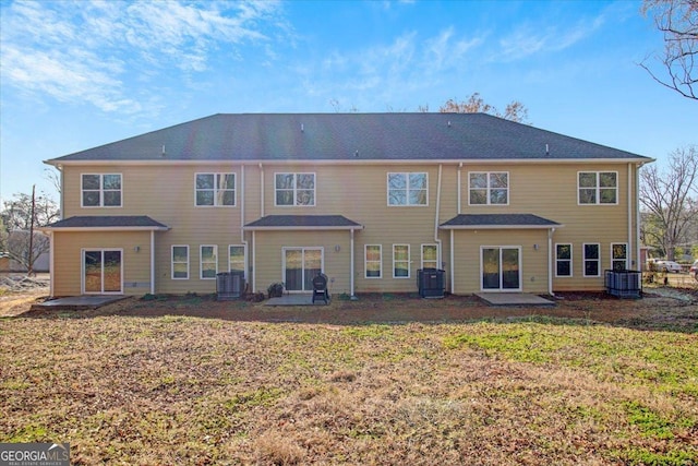 back of property featuring cooling unit and a yard