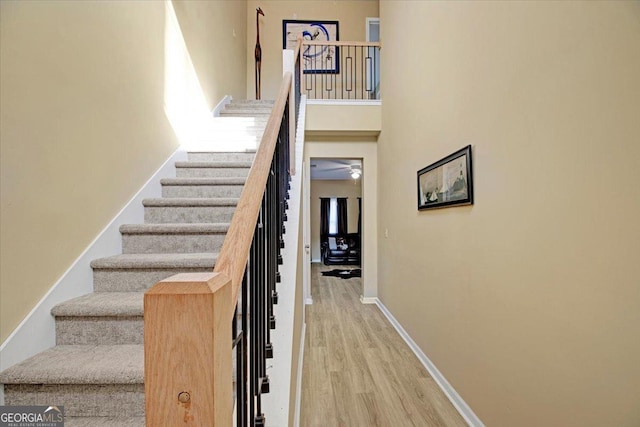 stairway featuring hardwood / wood-style flooring and a towering ceiling