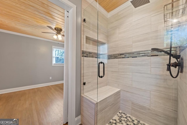 bathroom featuring hardwood / wood-style flooring, crown molding, ceiling fan, and walk in shower