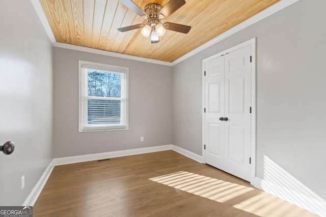 spare room featuring hardwood / wood-style flooring, crown molding, wooden ceiling, and ceiling fan