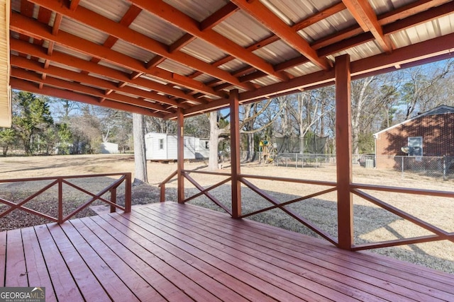 wooden deck featuring a shed and a trampoline