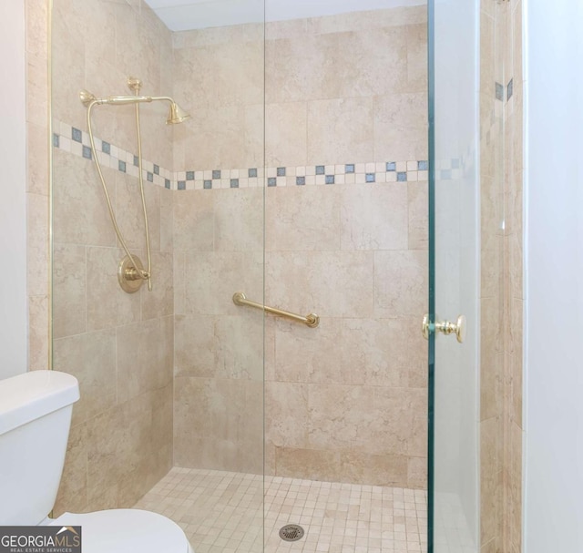 bathroom with a shower with shower door and toilet