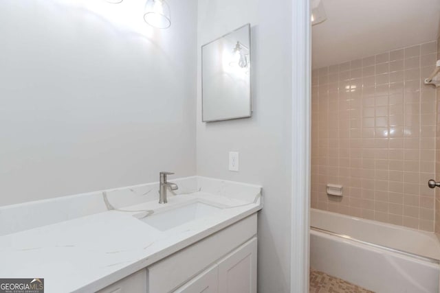 bathroom with tiled shower / bath and vanity