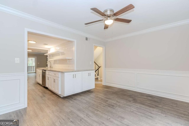 kitchen featuring white cabinetry, sink, ornamental molding, stainless steel dishwasher, and light hardwood / wood-style floors