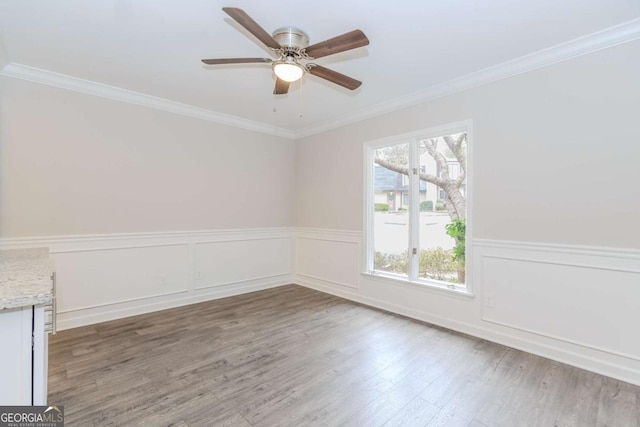 empty room with crown molding, wood-type flooring, and ceiling fan