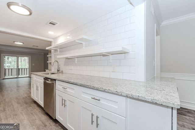 kitchen featuring white cabinetry, ornamental molding, stainless steel dishwasher, light hardwood / wood-style floors, and light stone countertops