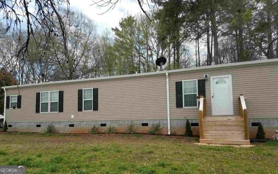 rear view of property featuring a lawn